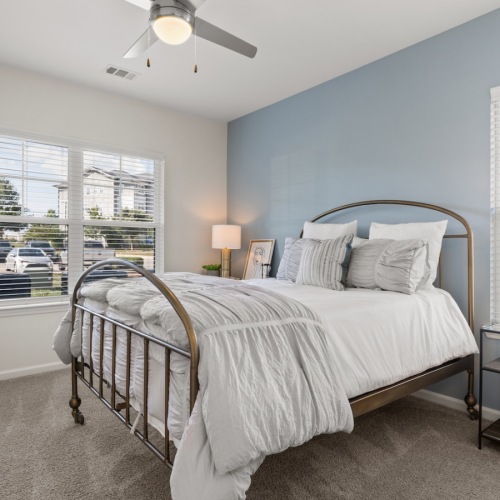 a bedroom with a bed and windows